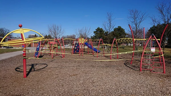 Children\'s playground is closed with yellow caution tape due coronavirus COVID-19 pandemic. No children allowed on the Playground  Ban on children\'s playgrounds. Flatten the curve fight the virus.