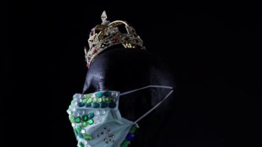 Tıbbi kentsel lüks mücevher maske ve altın taç takan oyuncak bebek kafası. Virüs hastalığı sırasında moda yaratıcı tasarım eğilimi, COVID 19 koronavirüs salgını ve kendini izole etme karantinası.