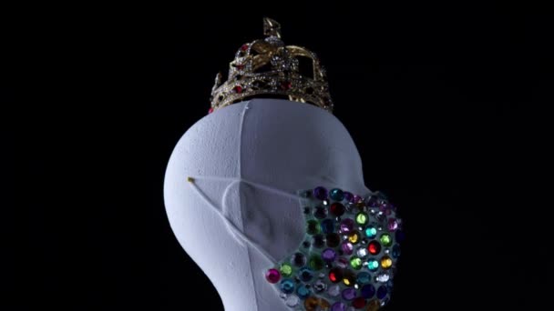 Міська медична маска і золота корона на жінці маннекін, що обертається. Кучерявий дорогий алмазний аксесуар для моделі знаменитостей під час вірусних захворювань Коронавірусна самоізоляція COVID-19 . — стокове відео