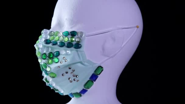 Woman mannequin wearing medical fashionably luxury gemstone face mask for protection from viruses and dust, slowly rotating while red and blue neon light flicker imitating medical emergency lights. — Stock Video