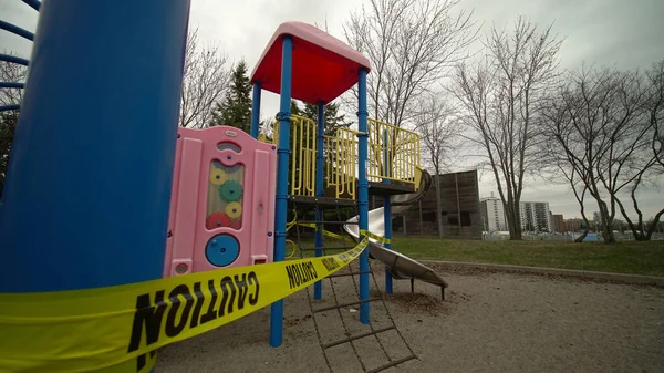Children\'s playground is closed. Focus on yellow caution tape due coronavirus COVID-19 pandemic. No children on the Playground is allowed.  Ban on children \'s playgrounds. The fight with virus.