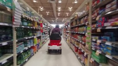 Toronto, Ontario, Kanada - 7 Nisan 2020: Coronavirus COVID-19 salgını sırasında marketten alışveriş yapan tıbbi maskeli ve eldiven giyen engelli kadın.