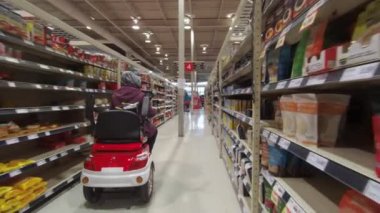 Toronto, Ontario, Kanada - 7 Nisan 2020: Coronavirus COVID-19 salgını sırasında marketten alışveriş yapan tıbbi maskeli ve eldiven giyen engelli kadın.