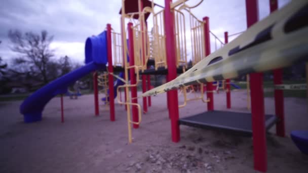 Der Kinderspielplatz ist geschlossen. Konzentrieren Sie sich auf gelbes Warnband aufgrund der COVID-19-Pandemie. Kinder auf dem Spielplatz sind nicht gestattet. Verbot von Kinderspielplätzen. Der Kampf mit dem Virus. — Stockvideo