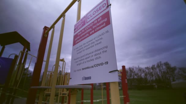 Toronto, Ontario, Kanada - 7. April 2020: Schild für Schild, COVID-19 ALERT CLOSED, alle Parks, einschließlich Spielplätze, sind geschlossen. Üben Sie körperliche Distanz, zwei Meter voneinander entfernt. Verlassener Park — Stockvideo