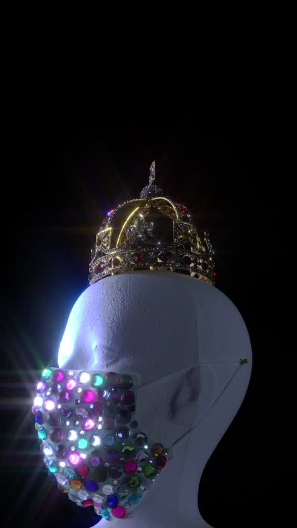 医療都市高級宝石保護マスクと金の王冠を身に着けている人形の頭。ウイルス病、 COVID 19コロナウイルスパンデミックと自己分離検疫中のファッション創造的なデザイントレンド. — ストック動画