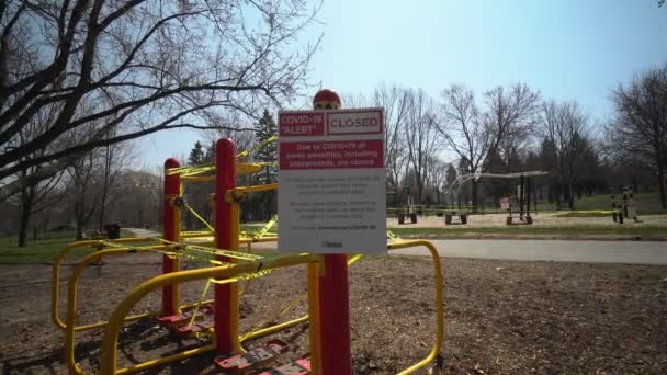 Toronto, Ontario, Kanada - 18. April 2020: Schild für Schild, COVID-19 ALERT CLOSED, alle Parks, einschließlich Spielplätze, sind geschlossen. Üben Sie körperliche Distanz, zwei Meter voneinander entfernt. Verlassener Park — Stockvideo
