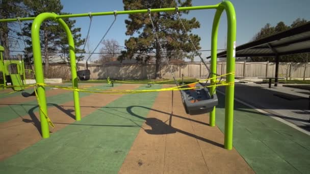 Торонто, Онтаріо, Канада - 7 квітня 2020: Playground покинуто і заблоковано належним чином COVID-19 coronavirus public closure, всі парки зручності, в тому числі ігрові майданчики, закриті. Жовта обережна стрічка — стокове відео