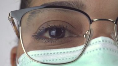 Mavi maskeli kadının ön görüntüsü yakın plan. Hastanede cerrahi koruyucu maske takan temel sağlık uzmanı. Coronavirus Covid-19 salgını sırasında kahraman hemşire..