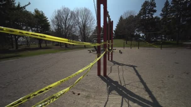 Toronto, Ontario, Kanada - 7 april 2020: Lekplats övergiven och låst på grund COVID-19 coronavirus varning stängning, alla parker bekvämligheter, inklusive lekplatser, är stängda. Gul varningstejp inlindad — Stockvideo