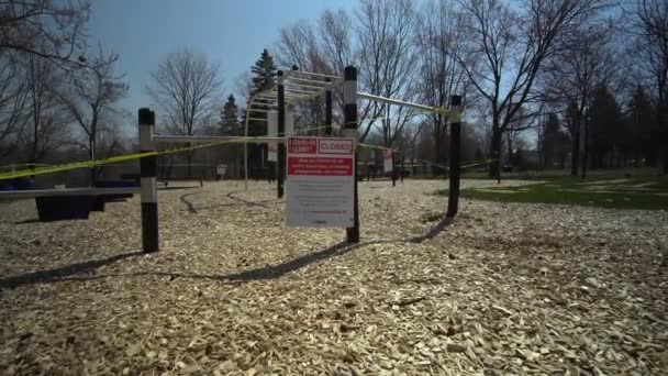 Toronto, Ontario, Kanada - 18. April 2020: Schild für Schild, COVID-19 ALERT CLOSED, alle Parks, einschließlich Spielplätze, sind geschlossen. Üben Sie körperliche Distanz, zwei Meter voneinander entfernt. Verlassener Park — Stockvideo