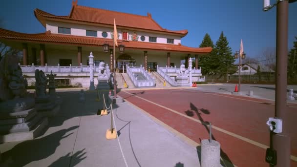 Toronto, Ontario, Canadá - 18 de abril de 2020: Templo Budista Jing Yin en la soleada mañana completamente vacío. Diferentes estatuas de Dios y criaturas cerca del templo. Buda, león y dragones . — Vídeos de Stock