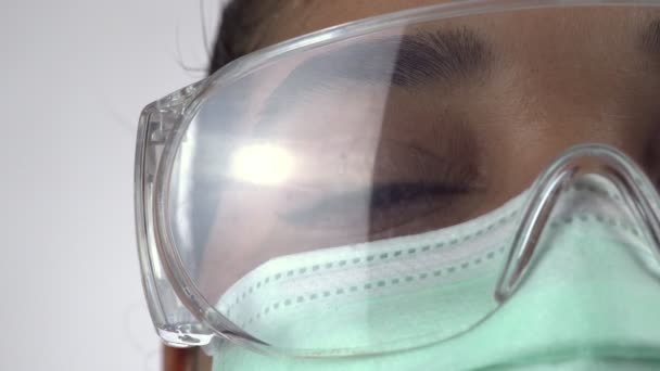 Macro primer plano de la mujer cirujano ojo, médico con mascarilla protectora y gafas listas para la operación. Profesional sanitario esencial en el hospital. Mujer afroamericana en la máscara desechable . — Vídeos de Stock