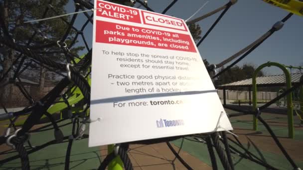 Торонто, Онтаріо, Канада - 18 квітня 2020: Підписання по місту, COVID-19 ALERT CLOSED, всі парки зручності, в тому числі ігрові майданчики, закриті. Практикуйте фізичне дистанціювання, на відстані двох метрів. Покинутий парк — стокове відео