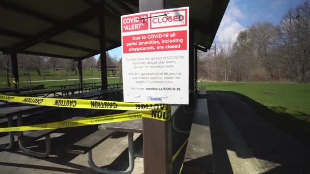 Торонто, Онтарио, Канада - 18 апреля 2020 года: Пикниковая зона полностью опустела и заброшена из-за контагиозного коронавируса COVID-19, предупреждение закрыто, все парки, включая детские площадки, закрыты . — стоковое видео