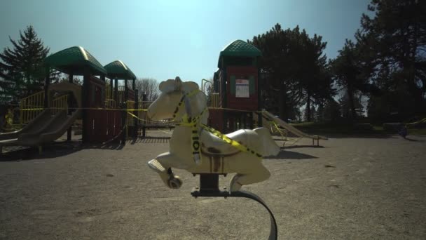 Toronto, Ontario, Canada - 18 aprile 2020: Parco giochi completamente vuoto e abbandonato, con piccolo cavallo per bambini, a causa del contagioso COVID-19 coronavirus, chiusura vigile, tutti i parchi sono chiusi . — Video Stock