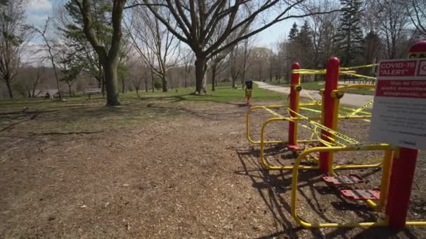 Toronto, Ontario, Canadá - 18 de abril de 2020: Firme por ciudad, COVID-19 ALERT CERRADO, todas las comodidades de los parques, incluidos los parques infantiles, están cerrados. Practica el distanciamiento físico, a dos metros de distancia. Parque abandonado — Vídeos de Stock