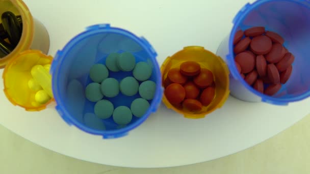 Különböző tabletták és palackok makró lövés felülről. A gyógyszertári asztal forgatása. Modern gyógyszer- és gyógyszeripar koncepció. A coronavirus COVID megelőzésére vagy kezelésére szolgáló kutatási és fejlesztési gyógyszerek. — Stock videók