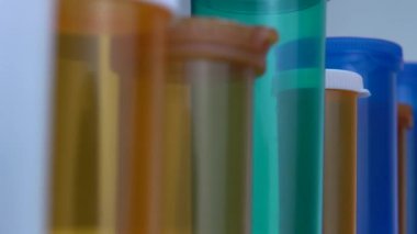 Farklı ilaç şişeleri makro yakın çekim. Eczane masasının yanında kayıyor. Modern ilaç ve eczane endüstrisi konsepti. Coronavirus COVID fikrini önlemek veya tedavi etmek için araştırma ve geliştirme ilaçları.