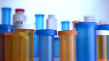 Farklı ilaç şişeleri makro yakın çekim. Eczane masasının yanında kayıyor. Modern ilaç ve eczane endüstrisi konsepti. Coronavirus COVID fikrini önlemek veya tedavi etmek için araştırma ve geliştirme ilaçları.