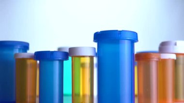 Farklı ilaç şişeleri makro yakın çekim. Eczane masasının yanında kayıyor. Modern ilaç ve eczane endüstrisi konsepti. Coronavirus COVID fikrini önlemek veya tedavi etmek için araştırma ve geliştirme ilaçları.