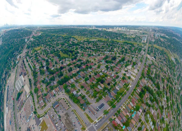 Aerial bird view of North American skyline at summer season. Hundreds of low rise houses and skyscrapers condominiums in the background. Panoramic cloudy sky day landscape in Toronto, Ontario, Canada.