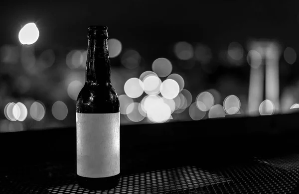 Botellas de vidrio blanco y negro de cerveza con luz de noche bokeh bac — Foto de Stock