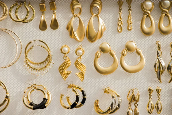 Gouden sieraden op een witte achtergrond. — Stockfoto