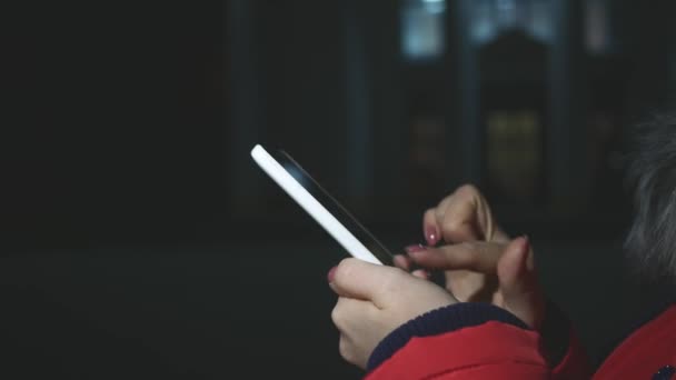Γυναίκα χρησιμοποιεί ένα έξυπνο τηλέφωνο τη νύχτα στην πόλη — Αρχείο Βίντεο