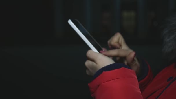 Mujer usando smartphone en la ciudad por la noche — Vídeos de Stock