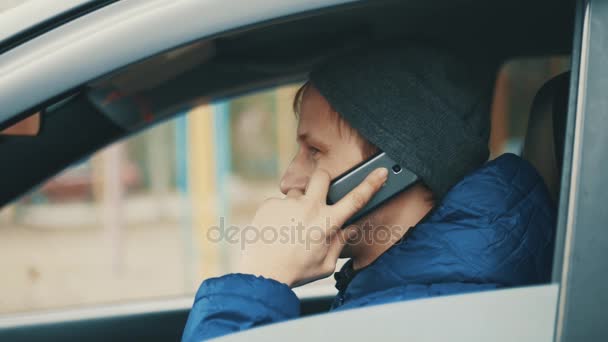 Бизнесмен разговаривает по мобильному во время вождения машины в городе — стоковое видео