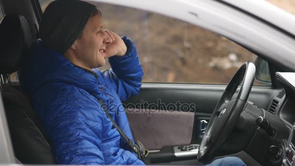 Un hombre sentado en el coche y hablando por teléfono móvil — Vídeos de Stock