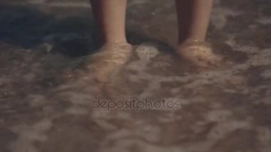 Çocuk bacaklar ve deniz kıyısı