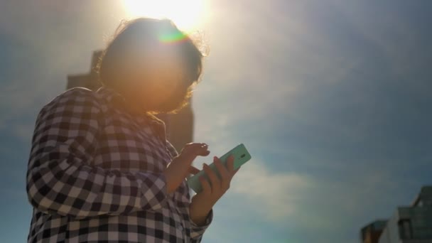 Κορίτσι στο ηλιοβασίλεμα πληκτρολόγηση σε κινητό τηλέφωνο κείμενο — Αρχείο Βίντεο