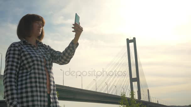 Dziewczyna robi selfie w przyrodzie z zachodu słońca — Wideo stockowe