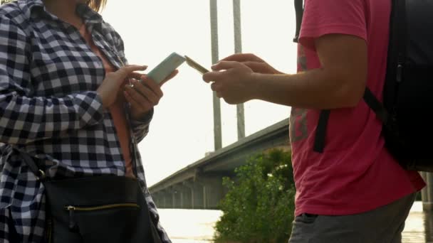 Молода пара в природі використовує мобільні телефони — стокове відео