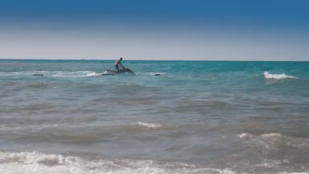 Um homem montado num jet ski ao pôr-do-sol — Vídeo de Stock