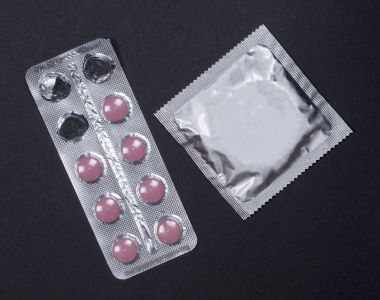 Prezervatif ve Pill, doğum kontrol hapı gebelik önleyici, siyah arka plan üzerine gebelik koruma.