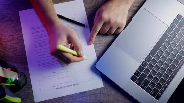 Top View för en man att skriva laptop, allokerar ett dokument en grön markör och signering — Stockvideo