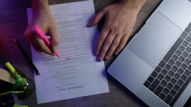 Pohled muže psát laptop shora, přidělí dokumentu značku růžová a podepisování — Stock video