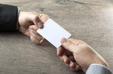 İş ortağı ahşap masa arka plan ile kartvizit vererek iş adamı