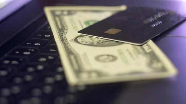 İki ABD Doları ve kredi kartları bir dizüstü bilgisayar klavye üstünde. Kavram görüntü veri ihlali, veri güvenliği, e-ticaret, online kredi kartı kullanın, veri şifrelemesi için. Seçici odak.
