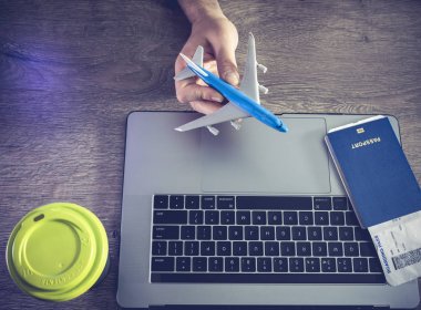 Erkekler tutuşun uçak bilet, pasaport ve dizüstü bilgisayarlar - üstten görünüm arka planı