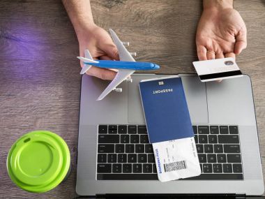 Uçak ve kredi kartı, Bilet, pasaport ve dizüstü bilgisayarlar - üstten görünüm arka planı erkekler ellerini tutun