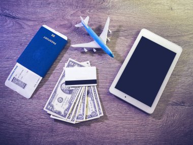 Uçak bileti, pasaport ve elektronik eşya, seyahate hazırlanıyor.
