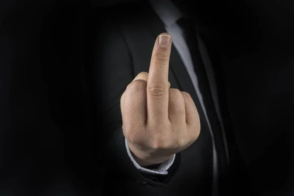 Business man with hand gesture represent bad word as fuck you on black background