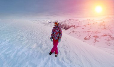 Karlı dağlarda günbatımı poz Kayak kıyafeti kız. Dağ Alpleri'nde - Avusturya Ischgl şehirde.