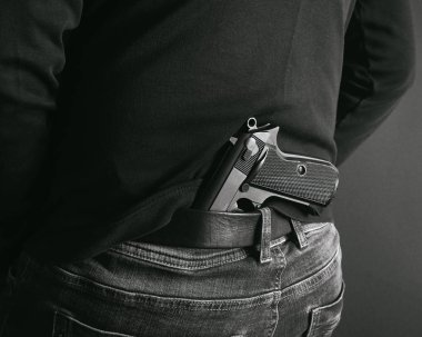 gangster silahını onun arkasına gizlemek. sırt ve beyaz fotoğraf