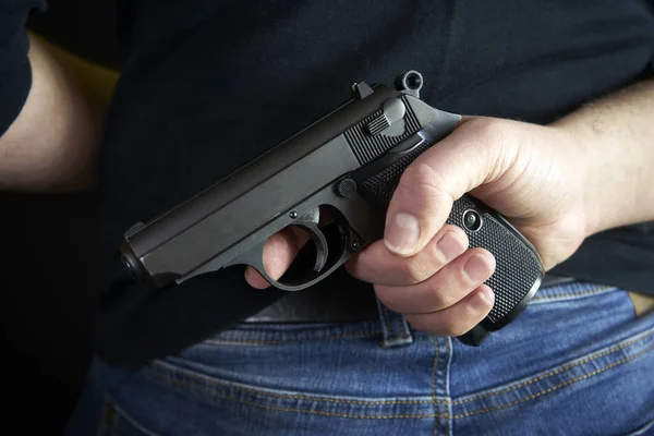 テロ泥棒男は彼の手で短い銃を保持しています 背面側の体に隠された銃 — ストック写真
