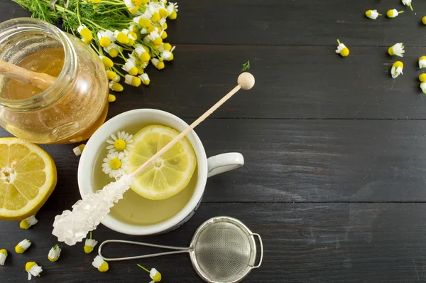Chá de camomila com fatia de limão e flores — Fotografia de Stock